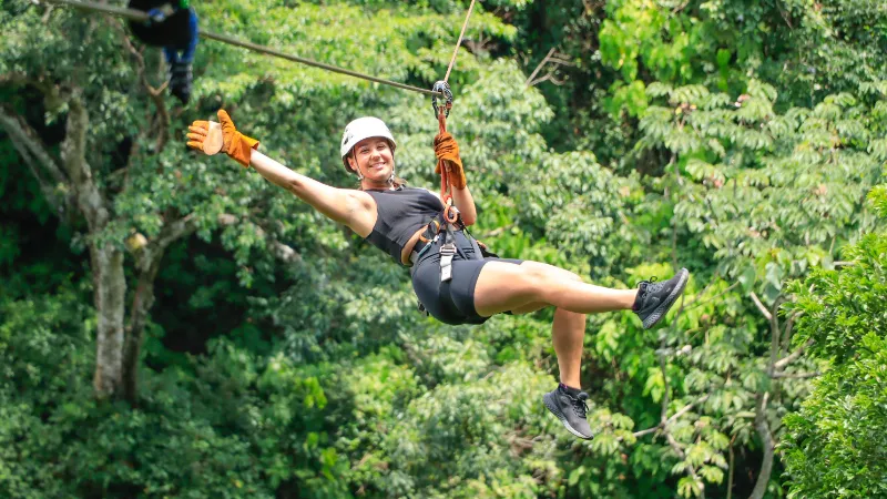 Woman ziplining through a tropical forest during a BestToursCR adventure in Guanacaste, Costa Rica