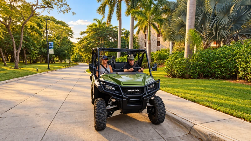 Green-and-black UTV carrying visitors on the driveway outside the JW Marriott Costa Elena lobby, surrounded by palms.